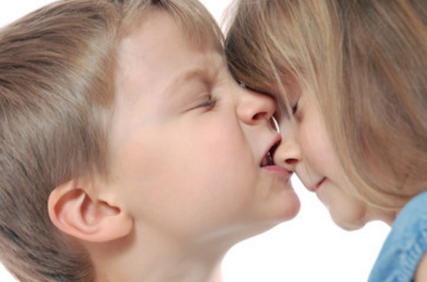 Мальчик пытается укусить девочку за носик