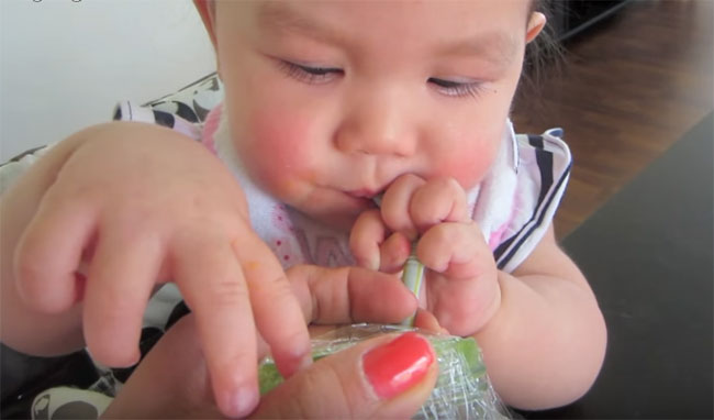 Ребенок пьет сок с трубочки