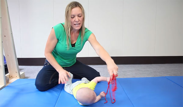 Малыш тянется за игрушкой и переворачивается