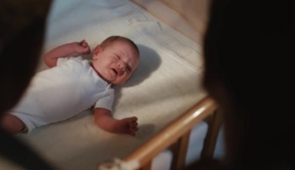 Грудной ребенок плачет в постеле