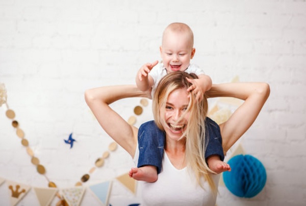 Ребенок сидит у мамы на шее