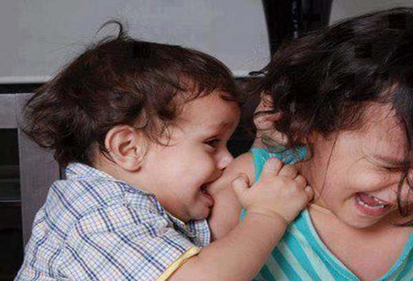 Мальчик кусает девочку за плечо