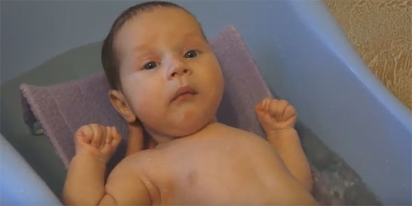 Ребенок купается в ванне с горкой