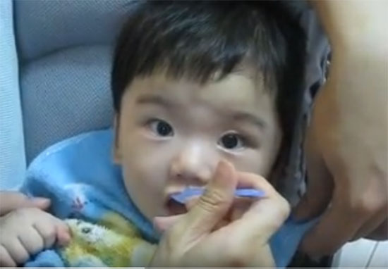 Малыша кормят овсянкой с ложечки