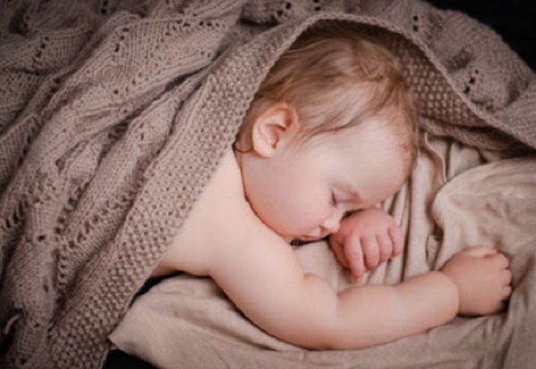 Малыш со вспотевшей головой спит