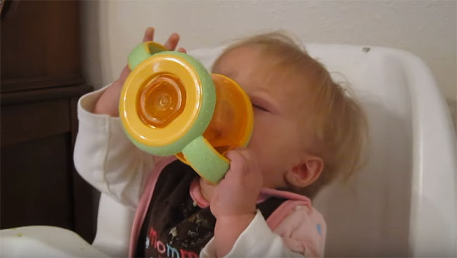 Ребенок пьет сок с бутылочки