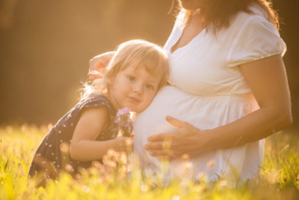 Девочка слушает, что происходит у мамы в животике