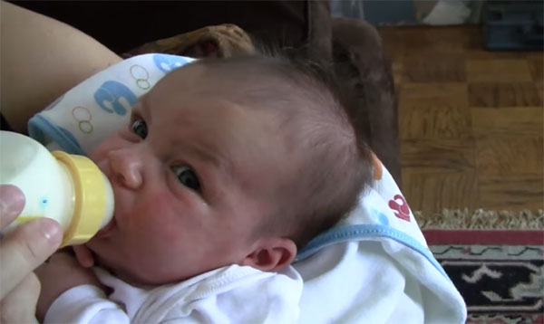 Малыш пьет из бутылочки