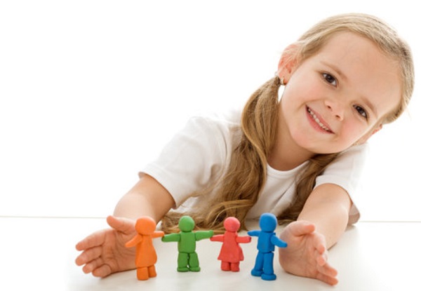 Девочка улыбается. Перед ней стоят пластилиновые фигурки