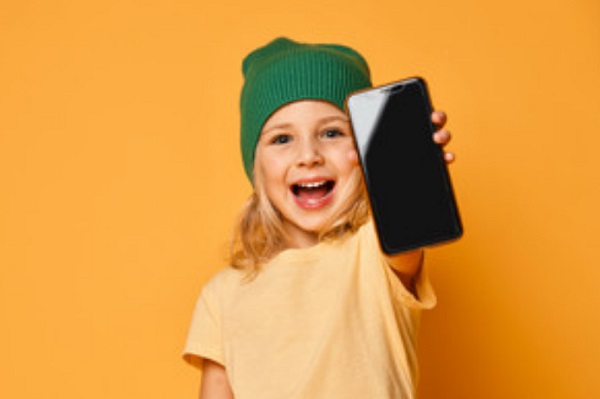 Счастливая девочка со смартфоном в руке