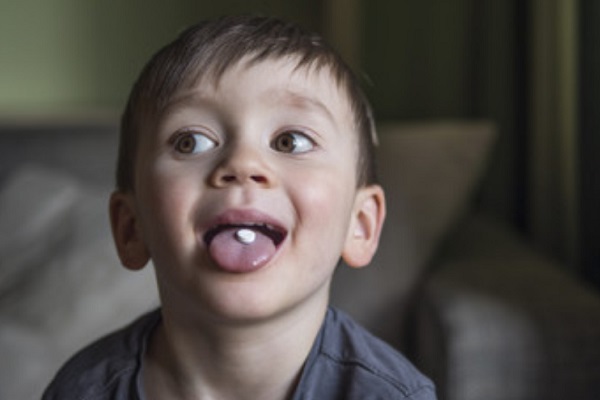 Ребенок с таблеткой на языке