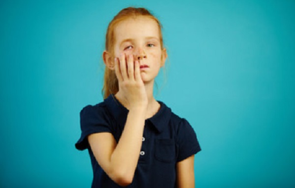 Девочка оттягивает свое нижнее веко вниз