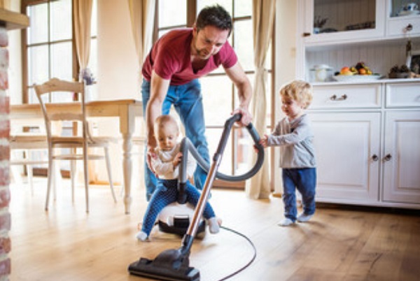Два маленьких мальчика помогают папе пылесосить