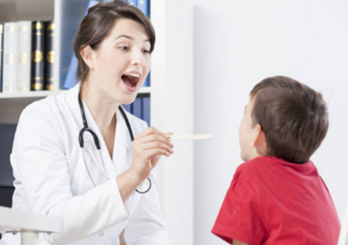 Врач осматривает горло мальчика