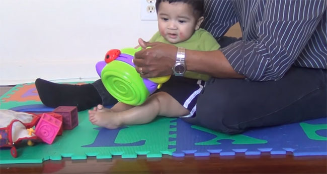 Ребенок тянется к игрушке