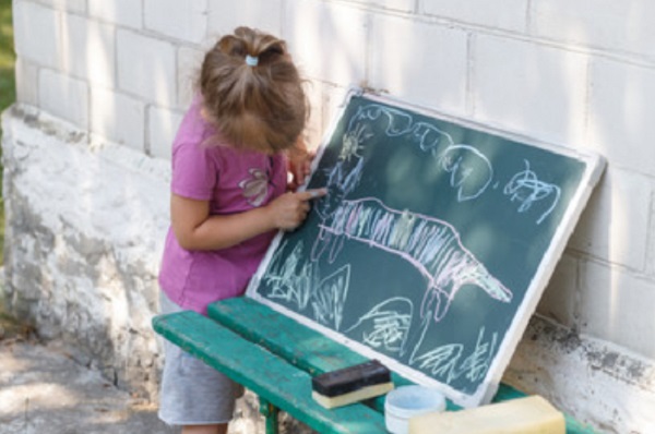 Девочка что-то рисует на доске