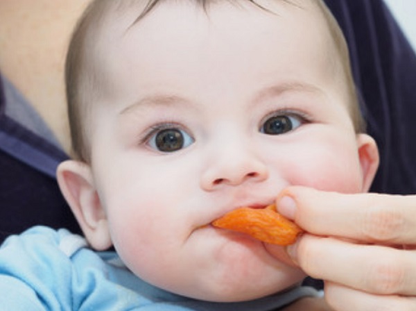 Маленький ребенок ест курагу