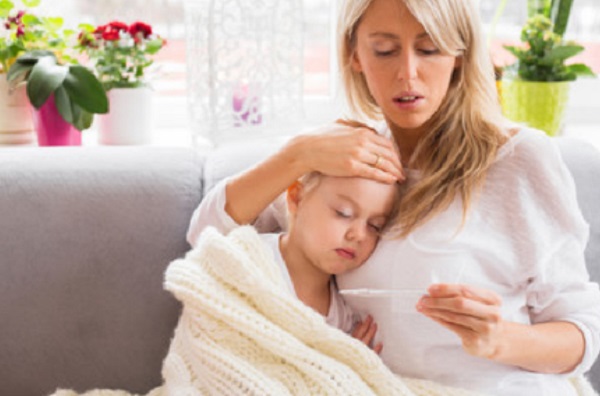 Девочка с закрытыми глазами облакотилась на маму. женщина держит в руке градусник