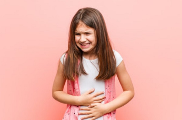Девочка держится за живот, который болит