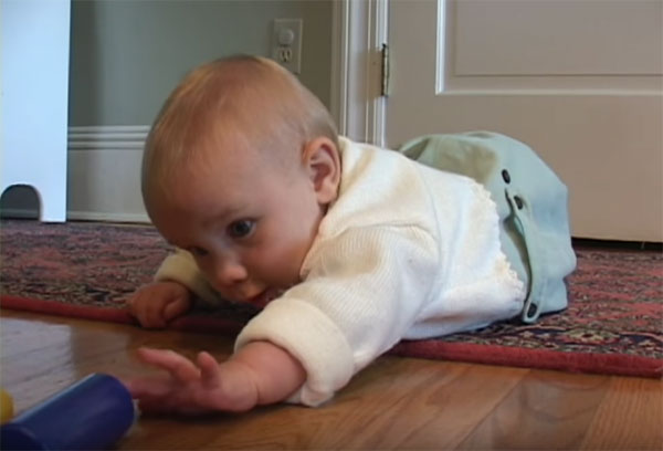 Малыш пытается дотянуться до игрушки