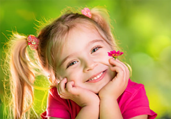 Девочка с хвостиками, держит цветочек и улыбается