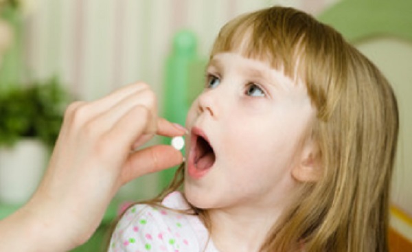 Девочка принимает таблетку