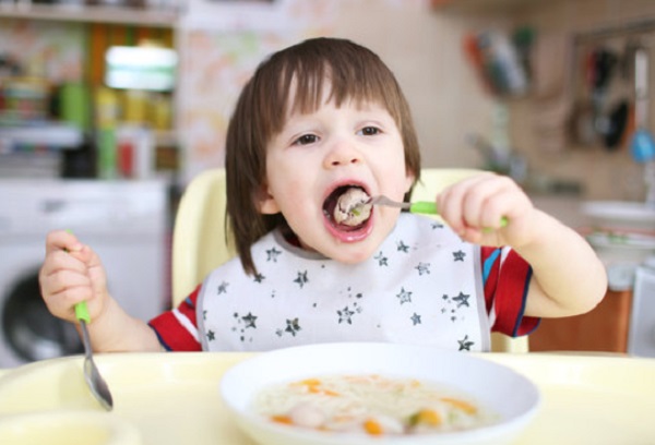 Ребенок ест мясную фрикадельку