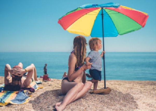 Ребенок с мамой под зонтиком на пляже