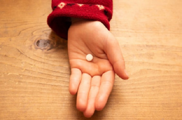 Ладонь ребенка с таблеткой