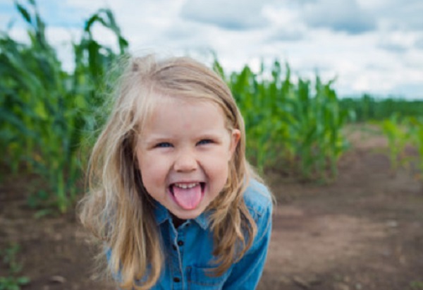 Веселая девочка показывает язык
