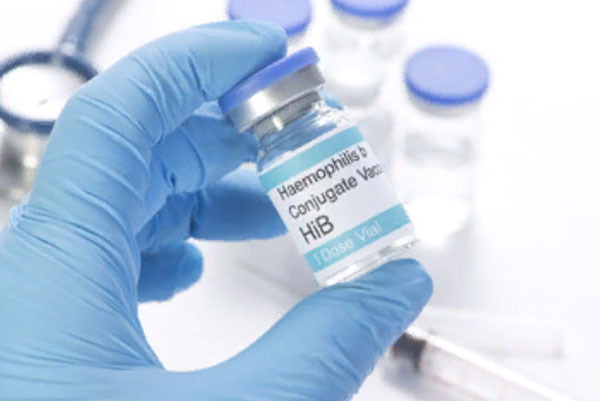 Рука в перчатке держит бутылочку с вакциной