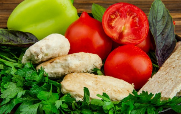 Паровые котлеты на фоне овощей и зелени