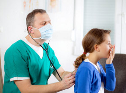 Врач прослушивает грудную клетку со спины пациентки, которая кашляет