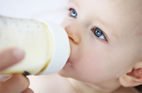 Грудничок пьет из бутылочки