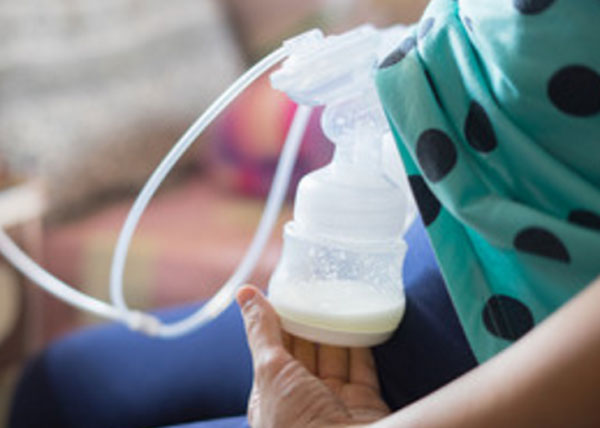 Женщина сцеживает грудное молоко