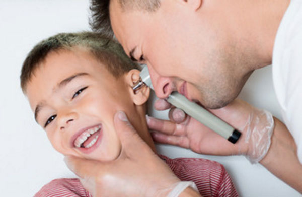 Отоларинголог осматривает ушной проход мальчика