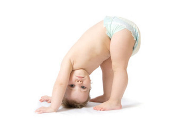 Ребенок в одном памперсе наклонился вниз головой