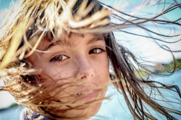 Волосы девочки разносит ветром