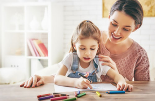 Мама смотрит, как дочка рисует