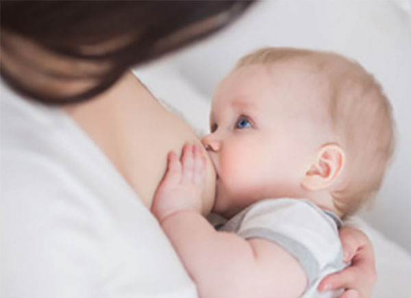 Женщина кормит ребенка грудью