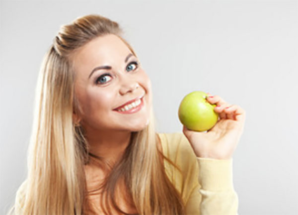 Женщина с желто - зеленым яблоком в руке