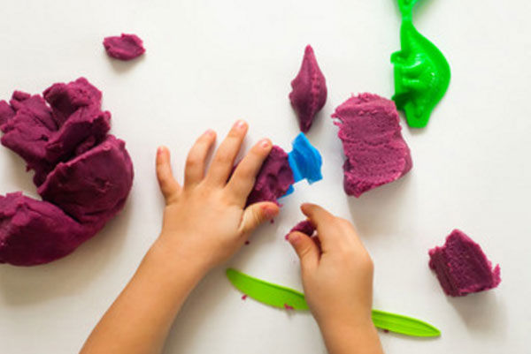 Ребенок лепит из цветного теста