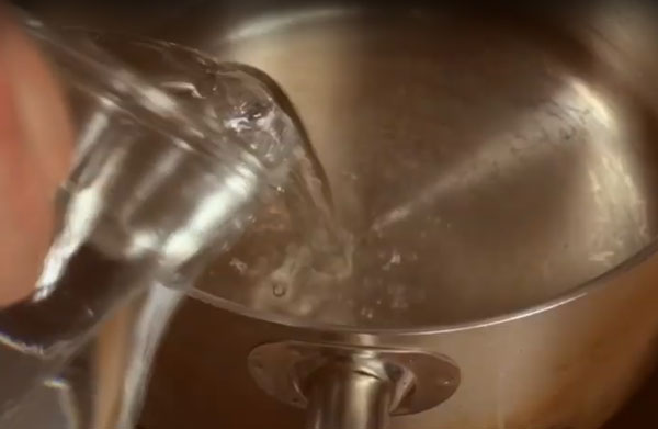 Наливание воды в кастрюлю