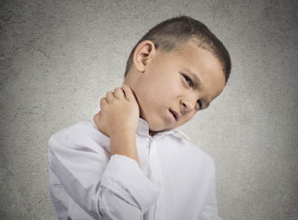 Мальчик держится за шею сбоку. Она болит