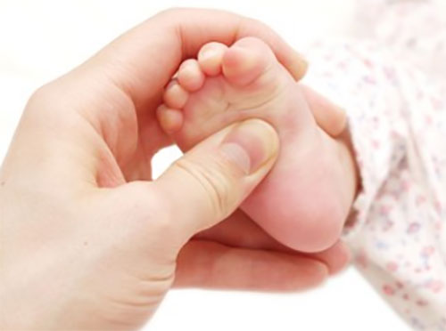 Мама делает массаж ножке грудничка