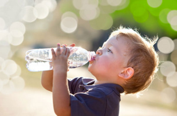 Мальчик пьет воду из бутылки
