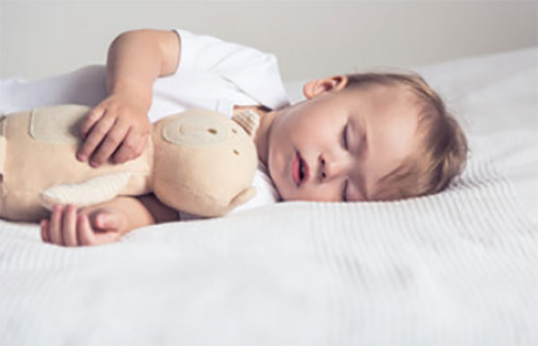 Ребенок спит на кровати