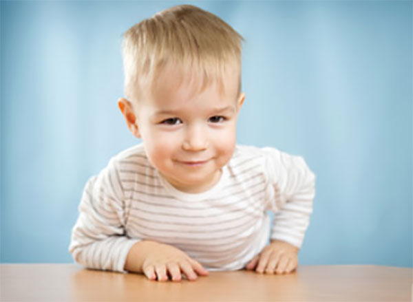 Двухлетний мальчик облокотился на стол