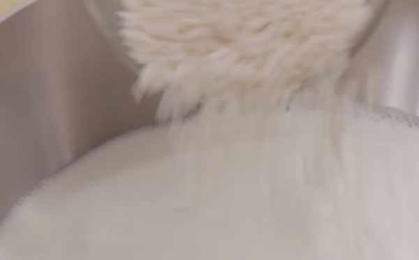 Рис всыпают в кастрюлю с молоком