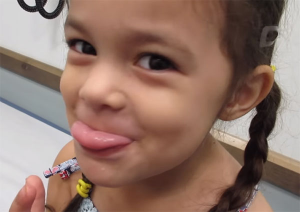 Девочка немного высунула язык